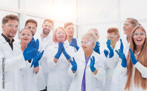 large group of medical researchers applauding together.