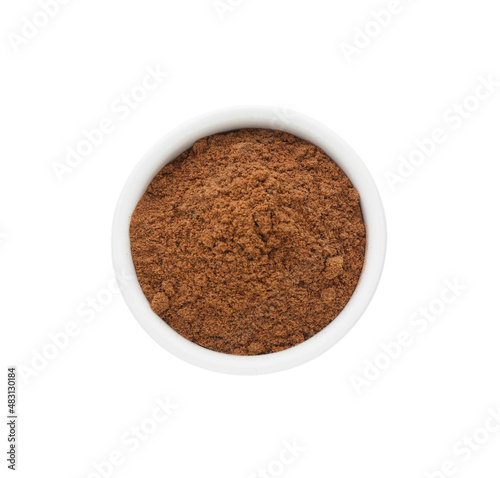 Bowl with nutmeg powder on white background, top view