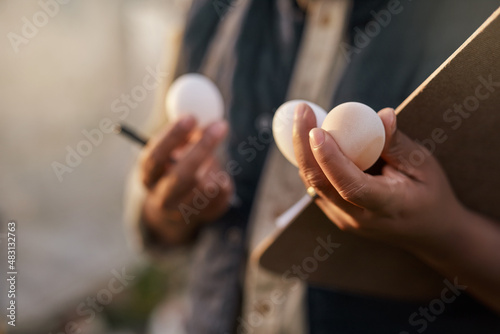 All ready for distribution. Shot of an unrecognisable farmer inspecting the quality of eggs on his farm.