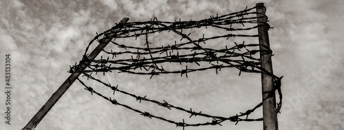 Horizontal banner or header with barbed wire on the concrete fence  - Concept of imprisonment and deportation - Commemoration of the victims of the holocaust photo