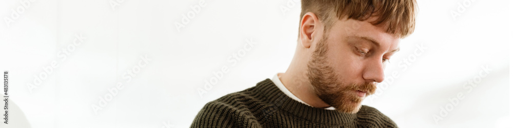 Obraz premium Young ginger man writing down notes while working in office