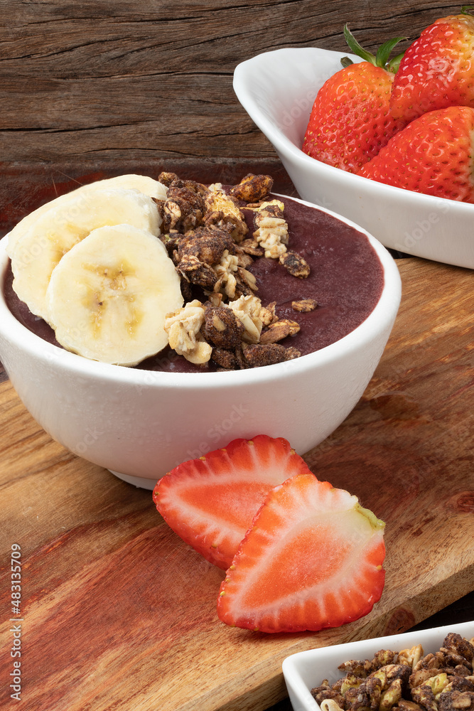 Açaí in a bowl served with fruits and granola. Açaí in a bowl served with fruits and granola.
