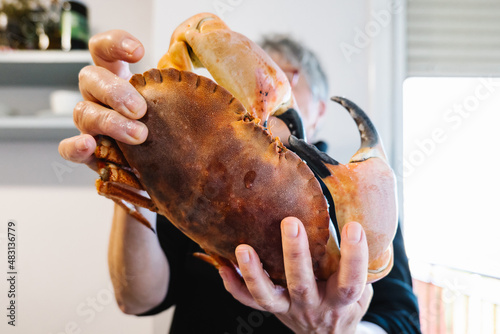 Woman showing raw crab in kitchen photo