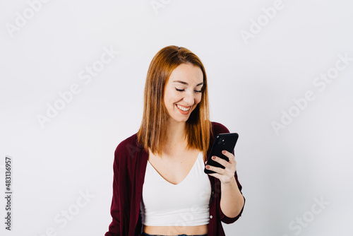 Smiling redhead woman using cellphone photo