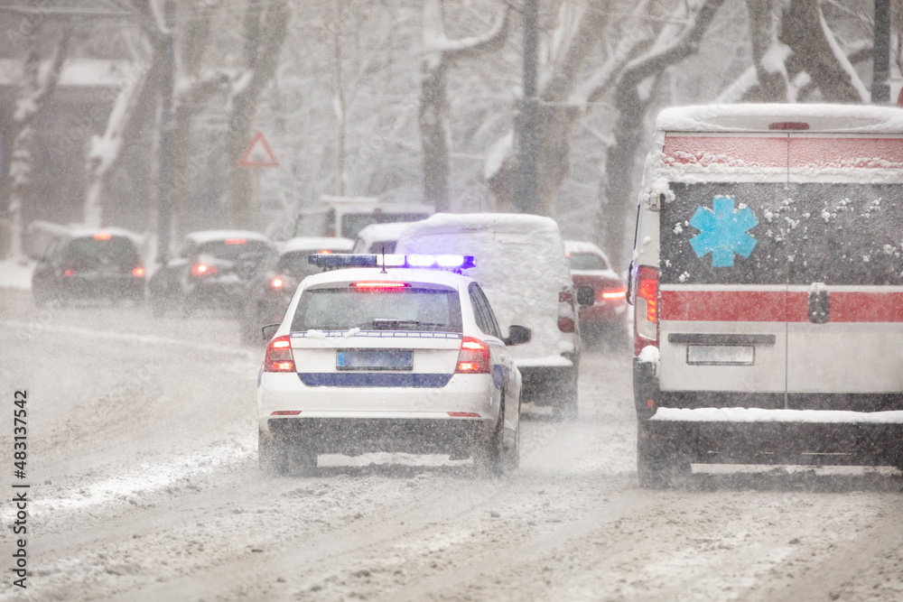 911 ambulance van and police car rushing through traffic during heavy ...