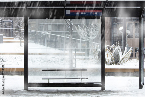Empty urban bus stop during heavy witner snowfall. photo