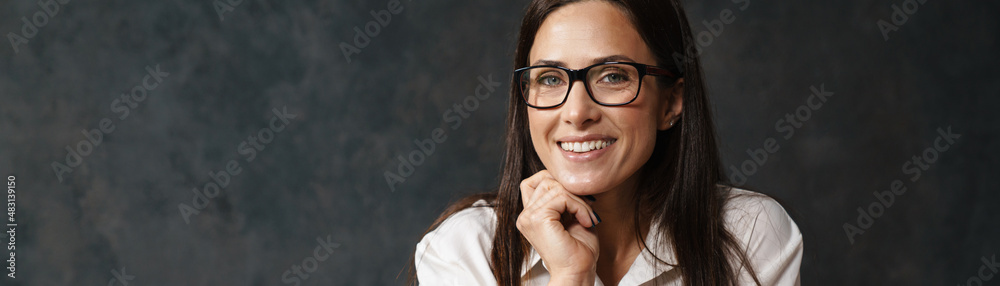 Mid aged brunette businesswoman in shirt sitting
