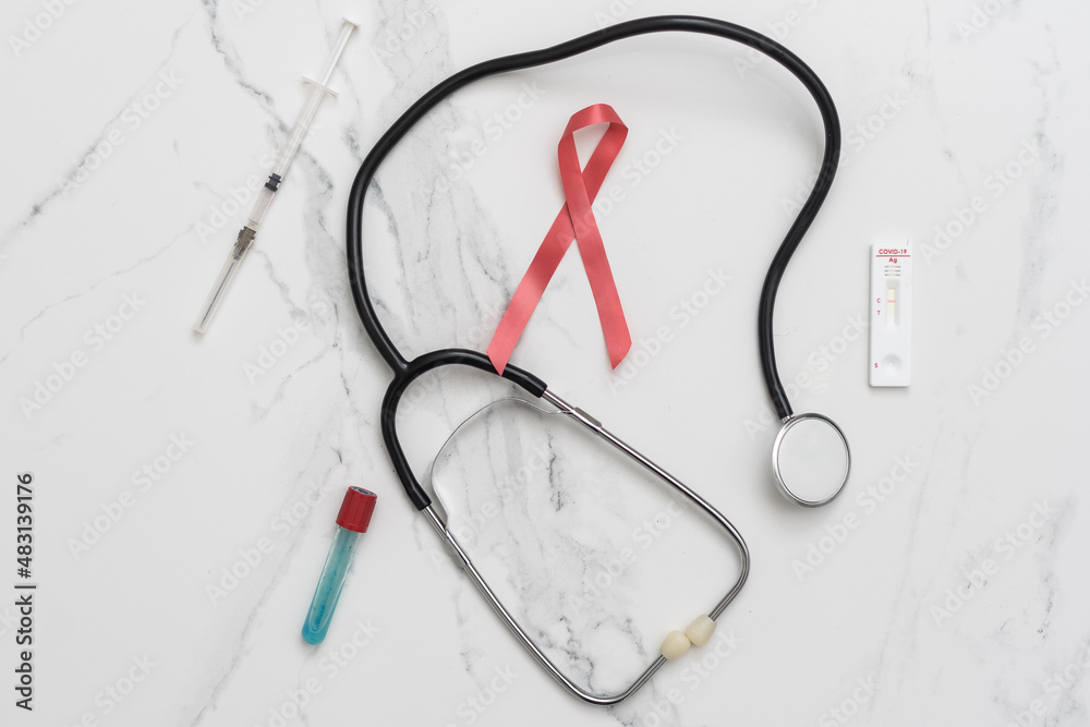 phonendoscope and red ribbon close-up. World aids day concept.