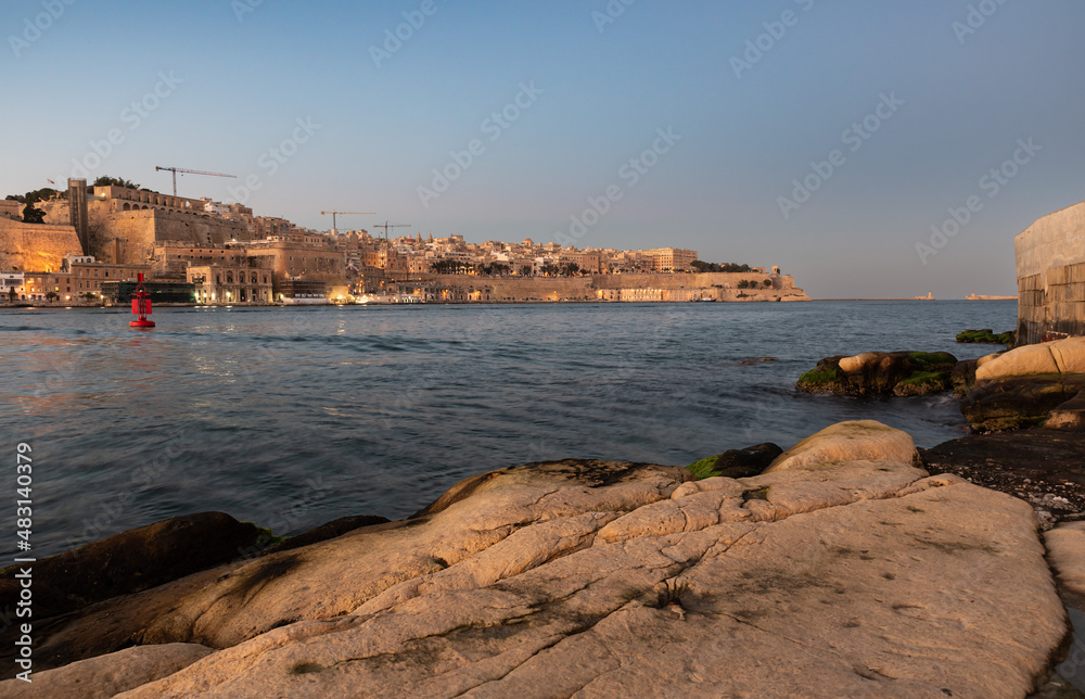 View over the harborand the Mediterranean sea at the Three cities during sunset, looking direction Valletta, Malta