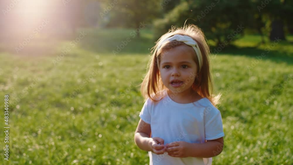 Posing a cute little girl in front of the camera in the middle of the park in a sunny day she are smiling very cute Posing a cute little girl in front of the camera in the middle of the park in a sunny day she are smiling very cute