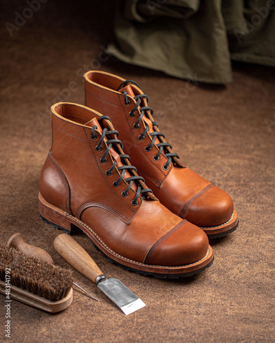 Handcrafted brown leather shoes with cobbler tools on the backgound