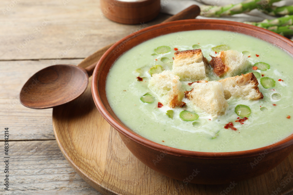 Delicious asparagus soup with croutons served on wooden table, closeup Delicious asparagus soup with croutons served on wooden table, closeup