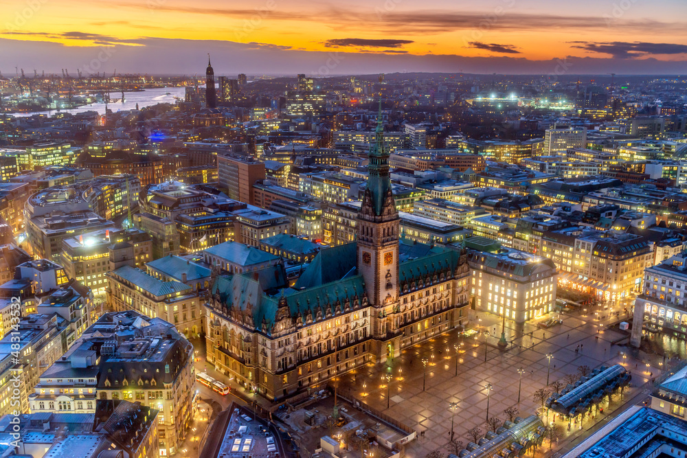 Panoramaaufnahme von Hamburg, mit der beleuchteten Hamburger City und dem Rathaus in der Abenddämmerung von oben (Aufnahme vom Januar 2022)