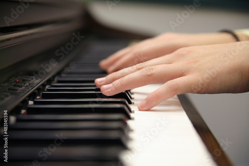 close-up of a person's hands playing piano