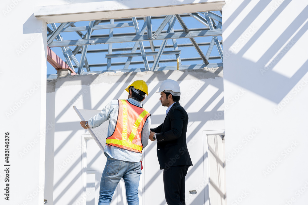Engineers are discussing data working and tablet or laptop with architectural project at new construction site,Engineering tools and construction concept. Engineers are discussing data working and tablet or laptop with architectural project at new construction site,Engineering tools and construction concept.
