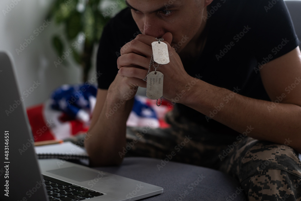 American caucasian soldier in USA military uniform in front of the computer.