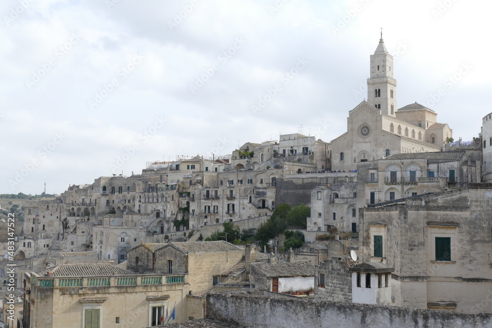 Cathedral with white sandstone facade and bell tower on the top of the hill in Matera