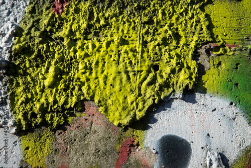 An old colorful concrete wall plastered with traces of old paint, texture.