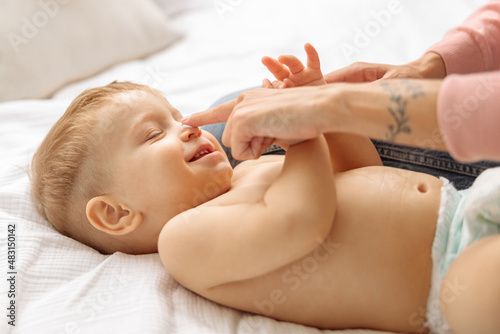 Young woman trying to touch her baby nose