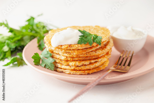 Potatoes pancakes latkes, flapjacks, hash brown or potato vada with parsley and sour cream  on table. photo