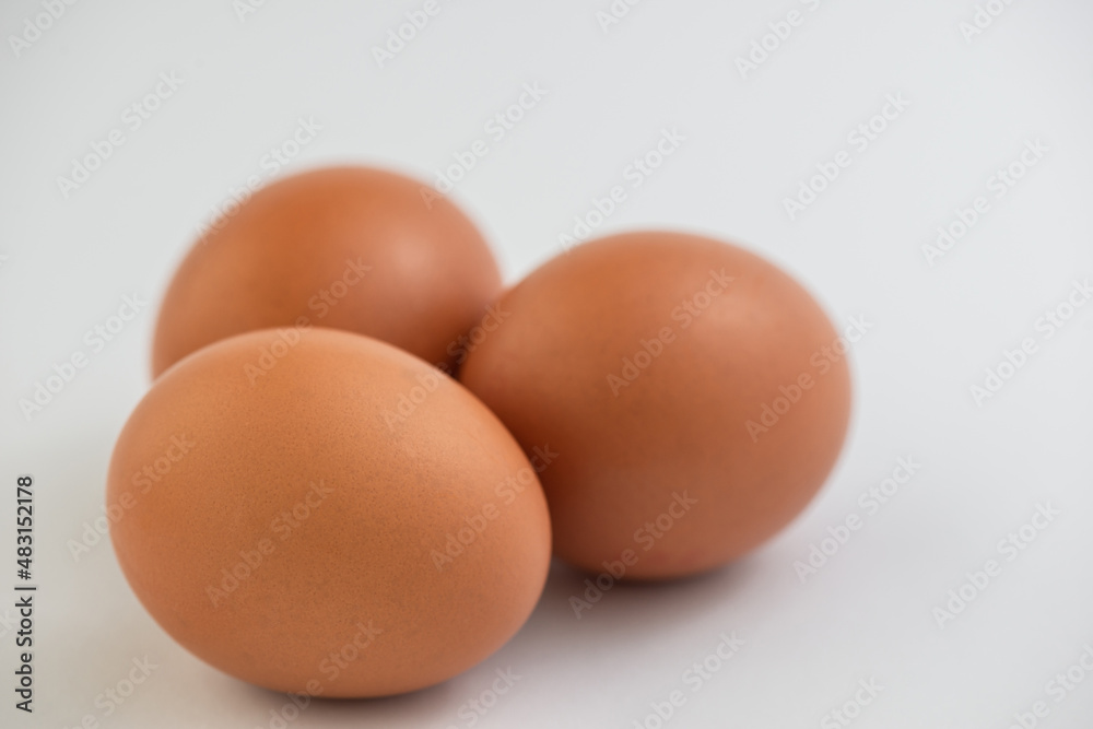 Closeup of fresh brown eggs over white background