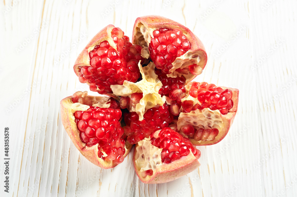 cut pomegranate fruit close-up on a white wooden table cut pomegranate fruit close-up on a white wooden table