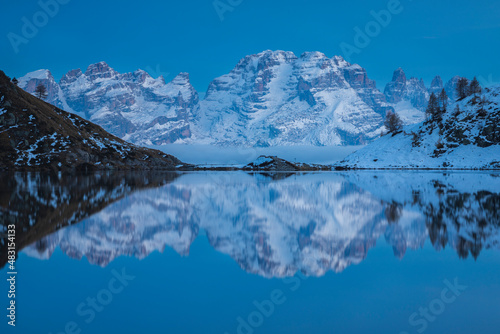 Brenta Dolomites reflected in the Ritorto lake during the blue hour, Adamello Brenta Natural Park, Trentino, Italy. photo
