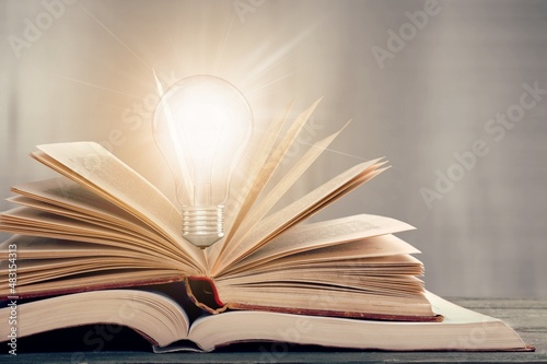 Bright lamp or glowing light bulb with book. Business success idea or solution concept. Thinking