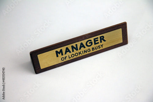 Manager of looking busy wood and metal sign on a white shelf