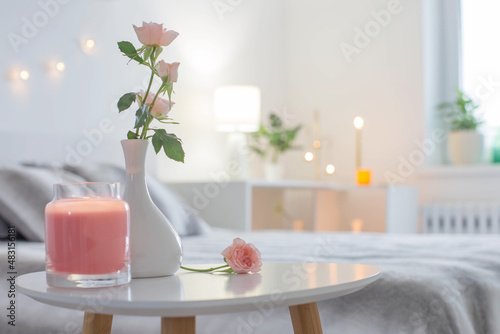 pink roses in vase on table in bedroom