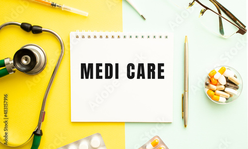 Text MEDI CARE on notebook with stethoscope and pen on yellow background.