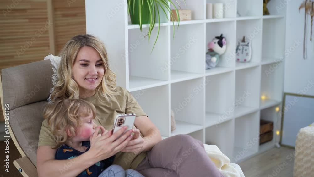 Mom and her little son use the phone, communicate via video chat, take photos Using technology concept Video 4k Mom and her little son use the phone, communicate via video chat, take photos Using technology concept Video 4k