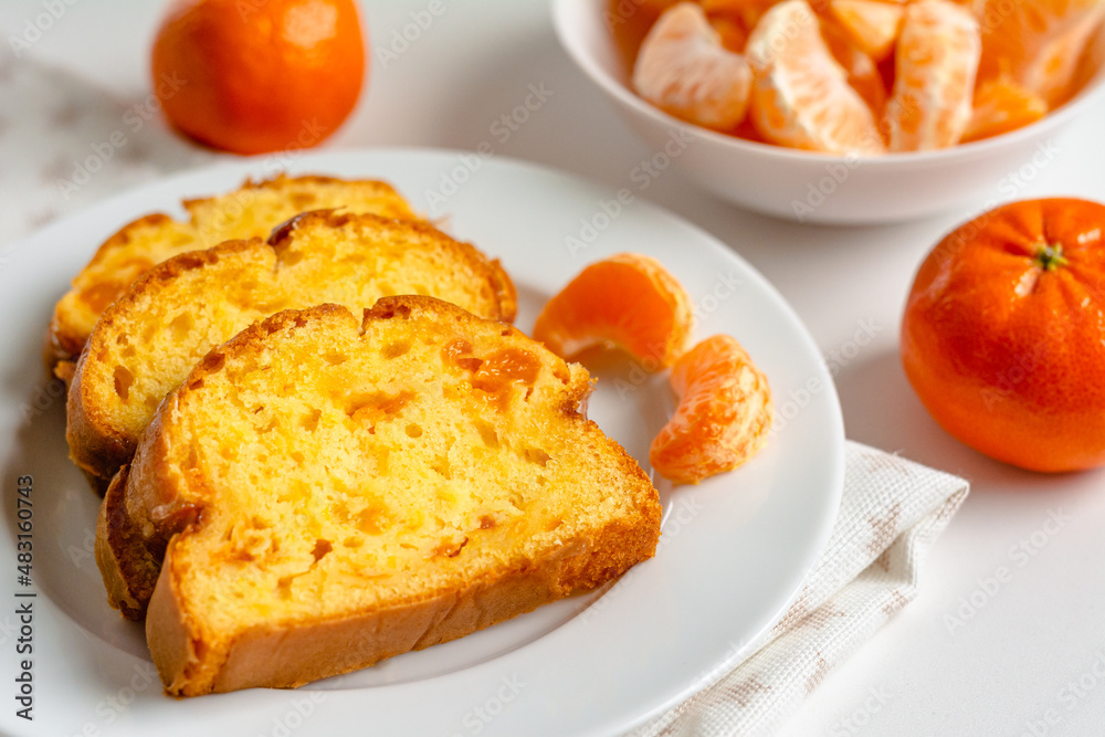 Homemade mandarin cake and tangerine on a plate. Homemade mandarin cake and tangerine on a plate.