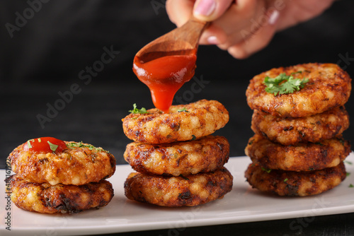 Sabudana vada wada pakora pakode fried snack chutney tapioca pearl sago woman hand serving north Indian street food Mahashivratri Shivratri Navratri Ram Navami fasting food vegetarian Indian festival  photo