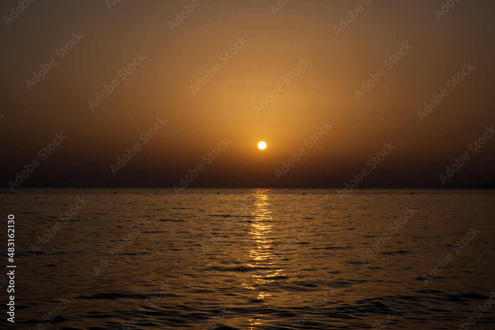 Naklejka premium Tranquil scene of beautiful sea at sunset. Scenic seascape. Orange and yellow sunset on the sea. Aerial panoramic view of sunset over sea.