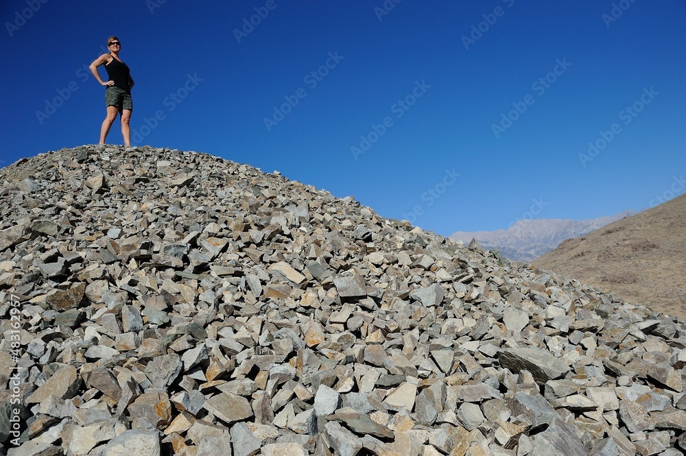 Woman stands on tailing pile of old gold mine, Alabama Hills, California, USA, MR