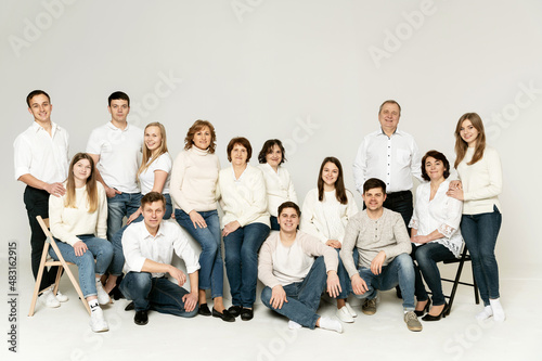 portrait of a large family on a white background. a large friendly family is dressed in red and black clothes. a group of people from different regions of the country. people of different ages