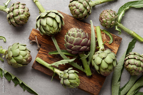 Fresh green artichokes cooking on wooden background photo
