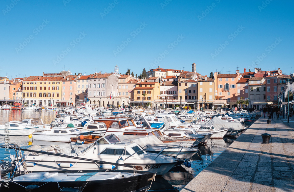 Beautiful fishing boats anchored in the Rovinj city port, Istria, Croatia, during crystal clear winter morning, lit by gentle sun