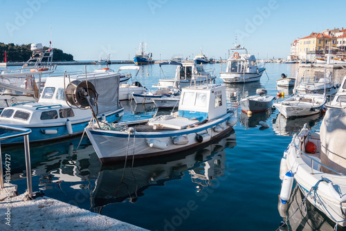 Beautiful fishing boats anchored in the Rovinj city port, Istria, Croatia, during crystal clear winter morning, lit by gentle sun © Miroslav Posavec