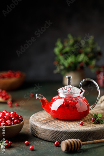 Hot cranberry drink in glass tea pot. lingonberry tea in a kettle 