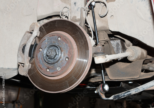 An old car brake disc. close-up of the brake disc and pads when replacing the wheel.