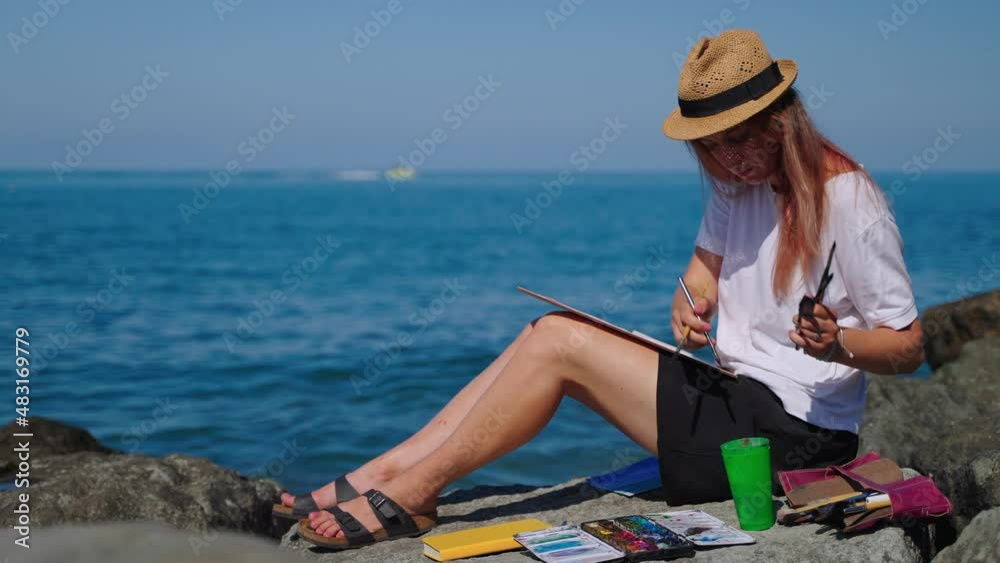 Woman relaxing with painting near the sea Woman relaxing with painting near the sea