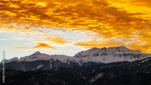 Beautiful scarlet clouds sunset in the winter mountains