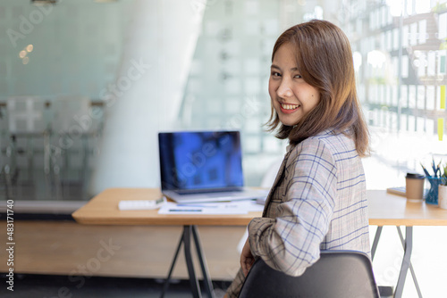 Portrait of a young beautiful Asian woman in a office room, concept image of Asian business woman, modern female executive, startup business woman, business leader woman. © kamiphotos