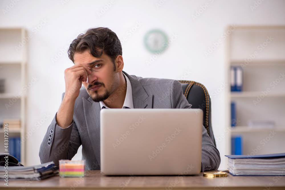 Young male employee sitting in the office Young male employee sitting in the office
