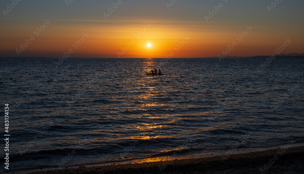 Fototapeta premium Tranquil scene of beautiful sea at sunset. Orange and yellow sunset on the sea. Aerial panoramic view of sunset over sea.
