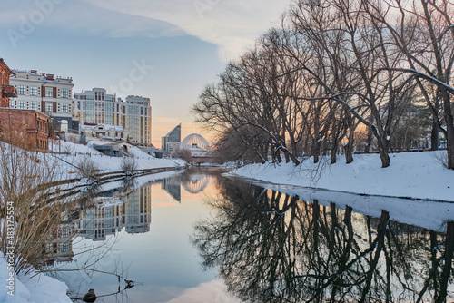 Winter cityscape of city of Yekaterinburg at sunset, Russia. Iset river, embankment, circus building