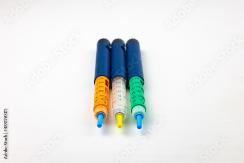 colored insulin pens on a white background