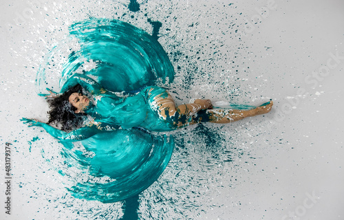 Bild auf Leinwand top view to expressive sexy woman lies elegant on the floor in turquoise blue co